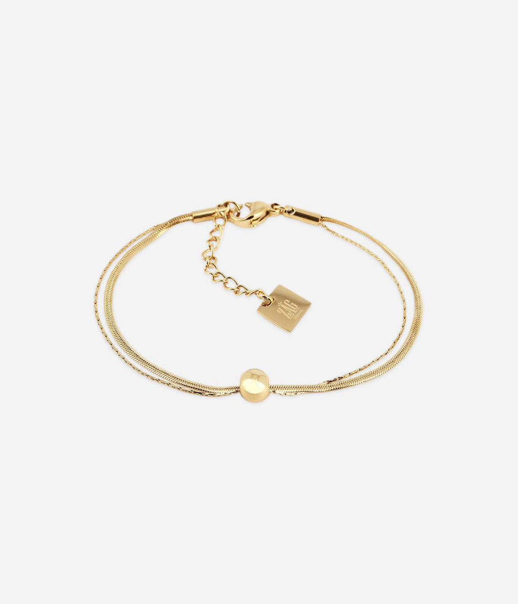 Bracelet Pepita Zag, double chaîne fine et boule de métal en acier doré à l'or fin